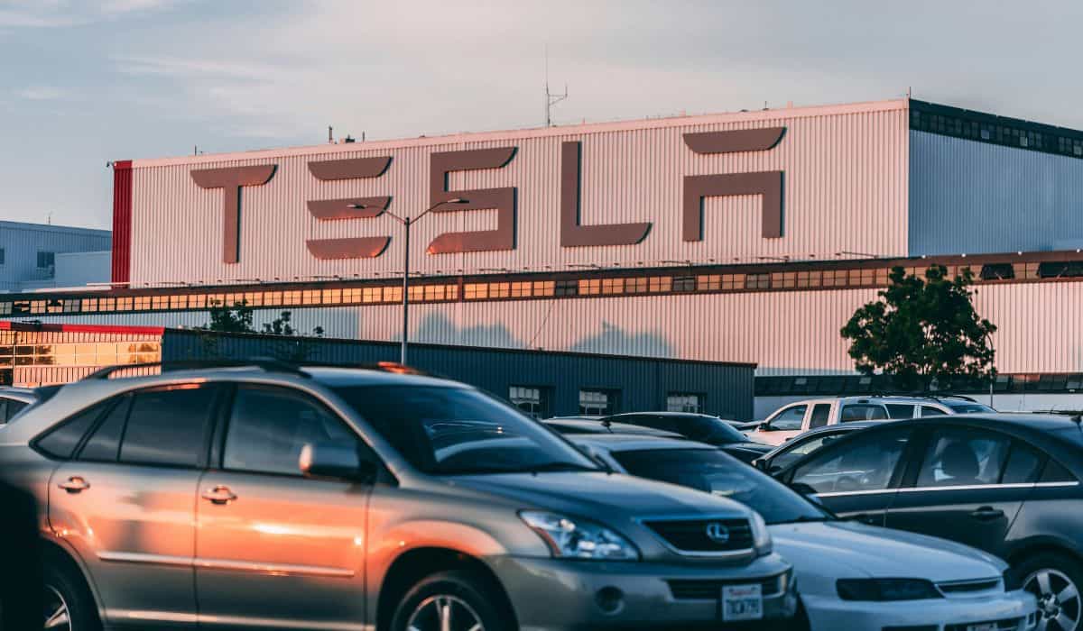 Hélicoptère de chaîne de télévision capte une cour remplie de voitures à l'usine Tesla