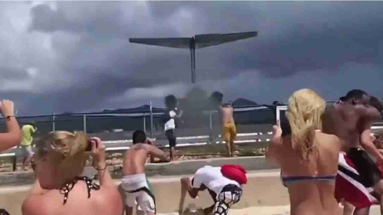 Toeristen op Maho Beach worden de zee ingetrokken door een windstoot veroorzaakt door het opstijgen van een vliegtuig